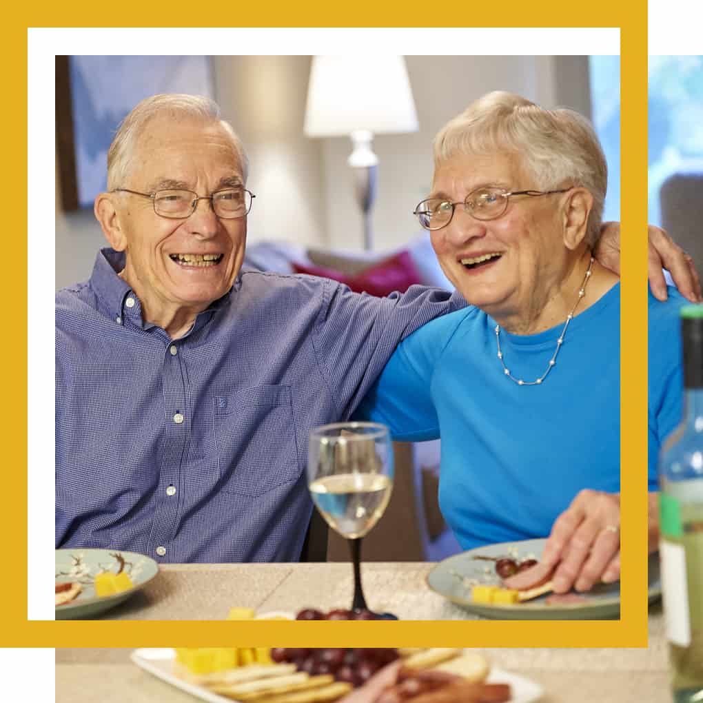 senior citizens smiling and enjoying dinner at Luther Manor in Wauwatosa, WI