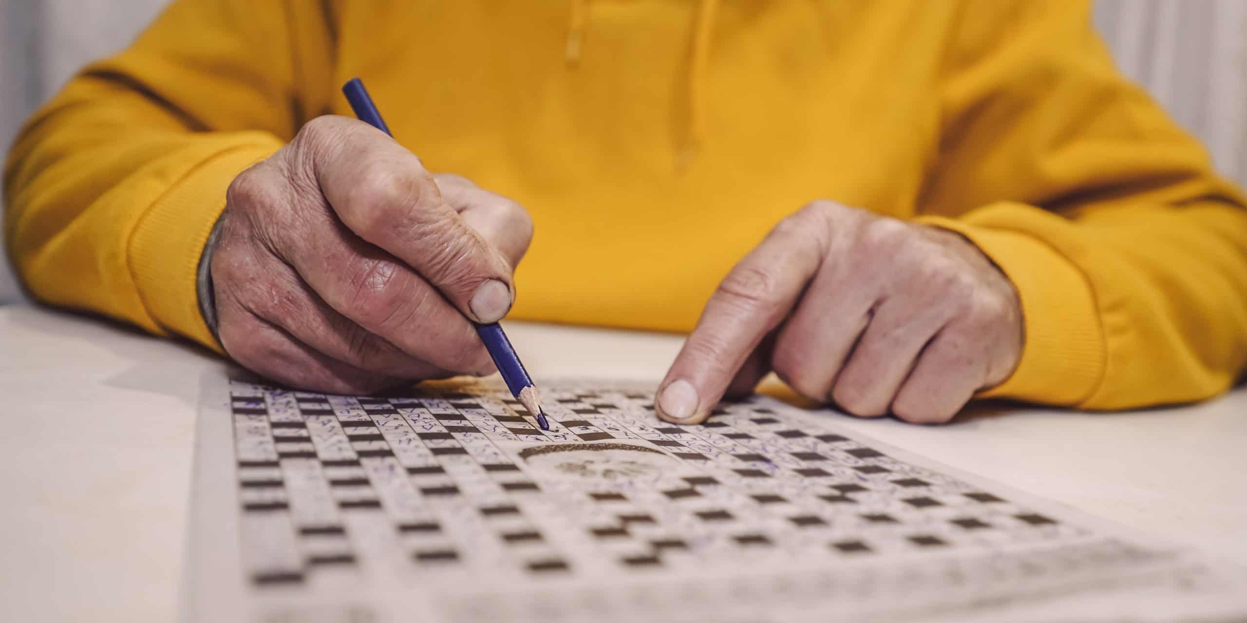 older person working on a crossword puzzle
